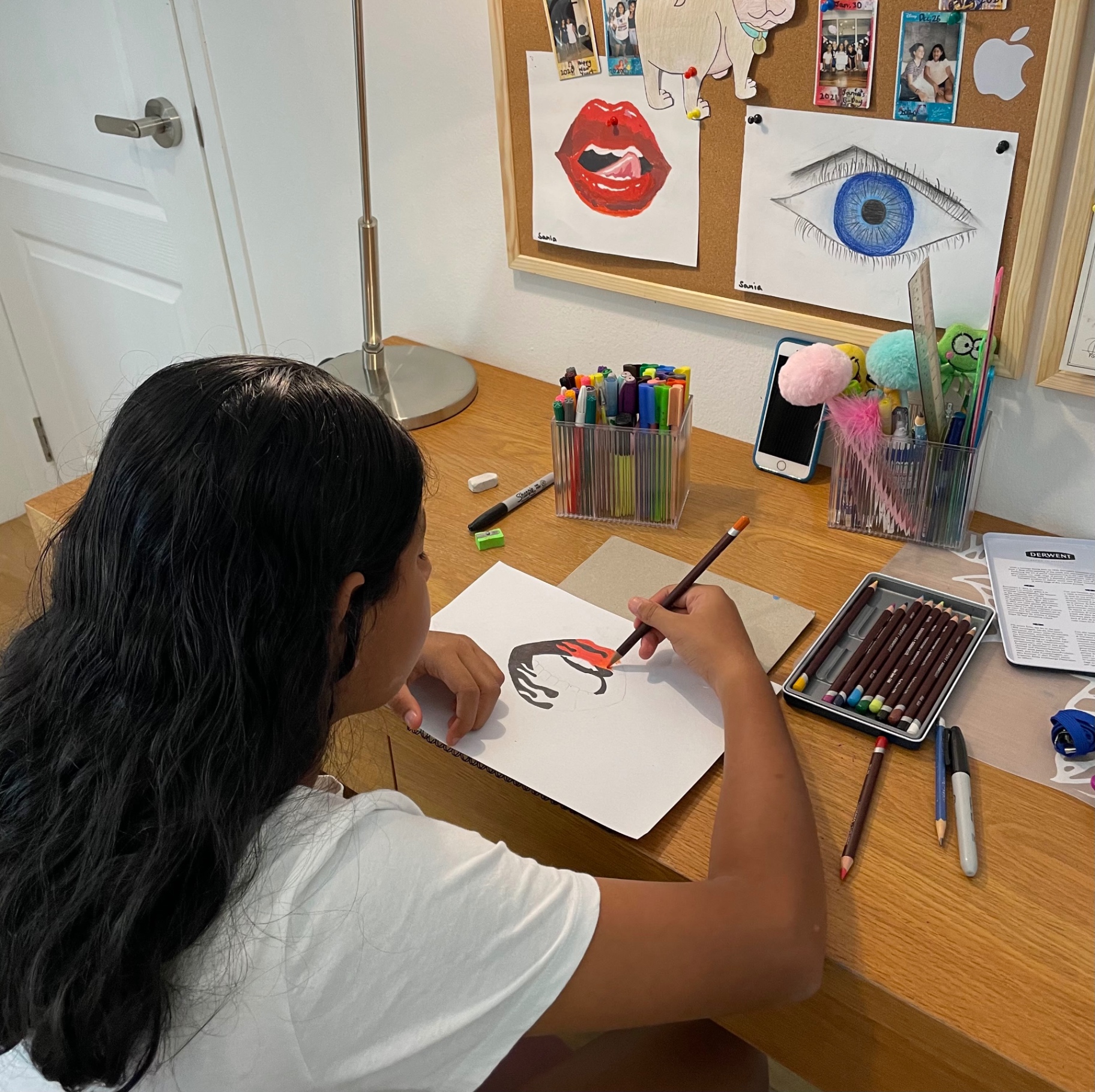 Sania sketching a portrait at her desk