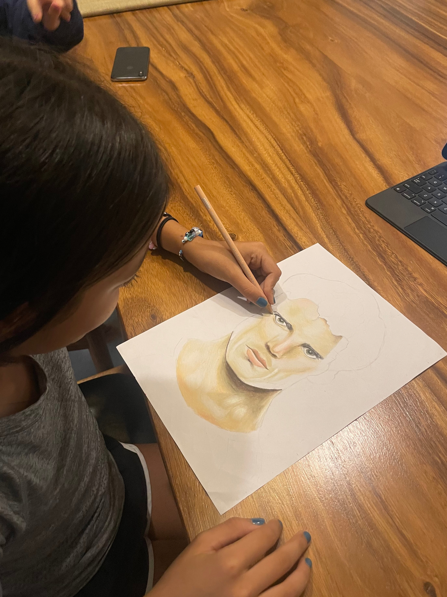 Young student drawing a colored pencil portrait
