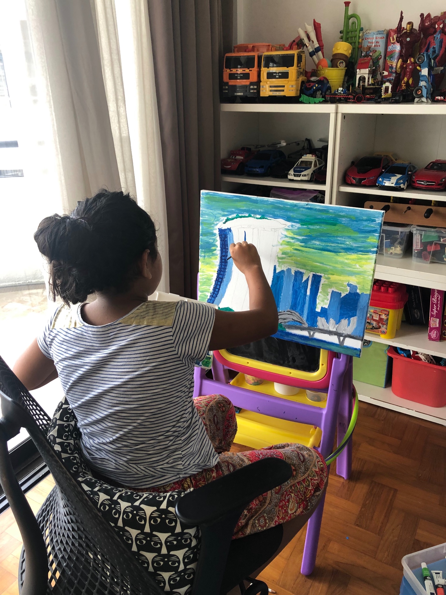 Young Sania painting the Marina Bay Sands skyline on a canvas