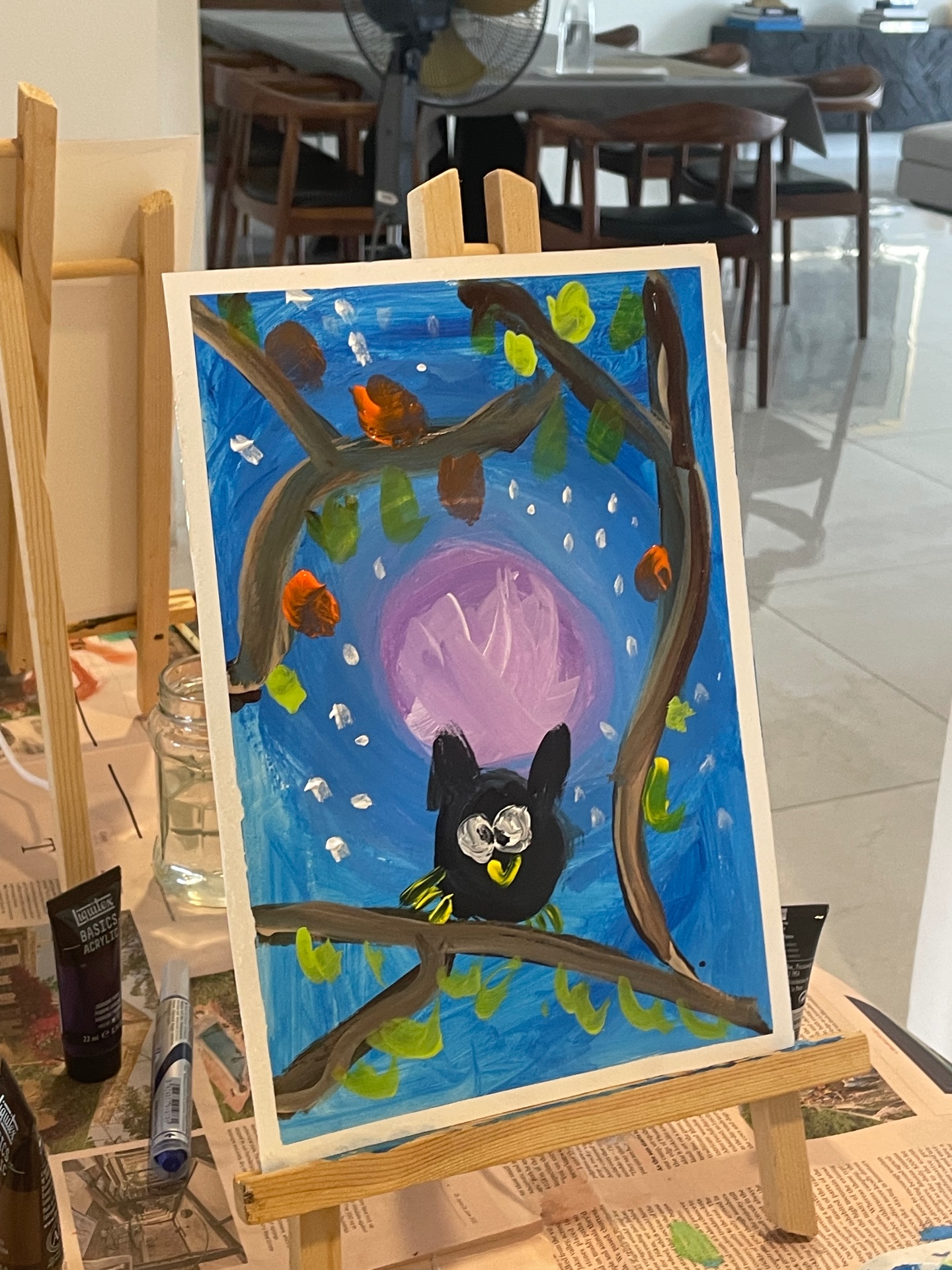 An owl painting on an easel in the studio